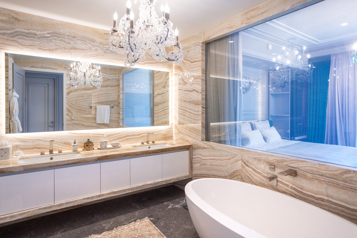 Glass wall connecting the primary bathroom to the bedroom beyond