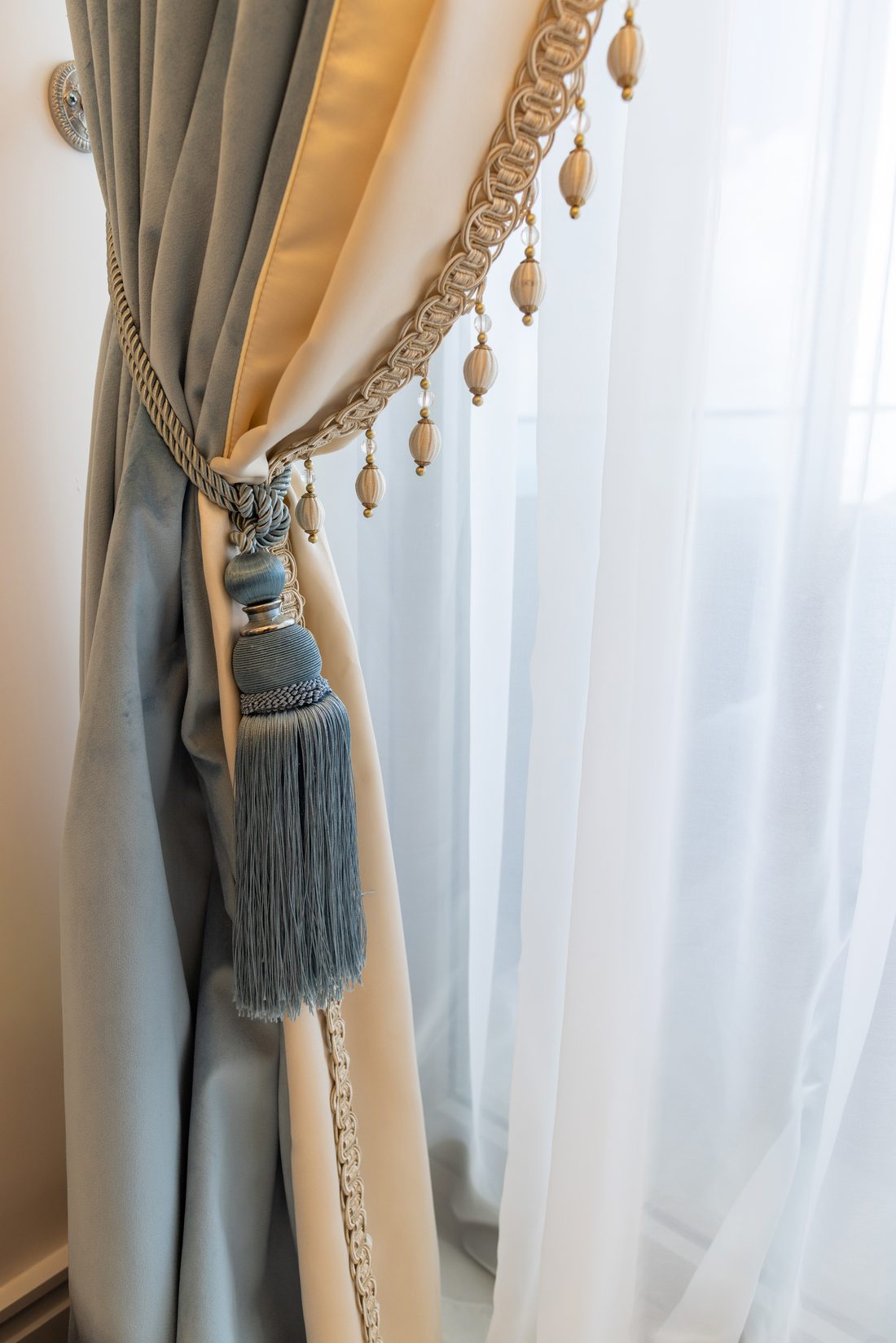 Detail of silk drapery with bullion tassel tieback and beaded trim