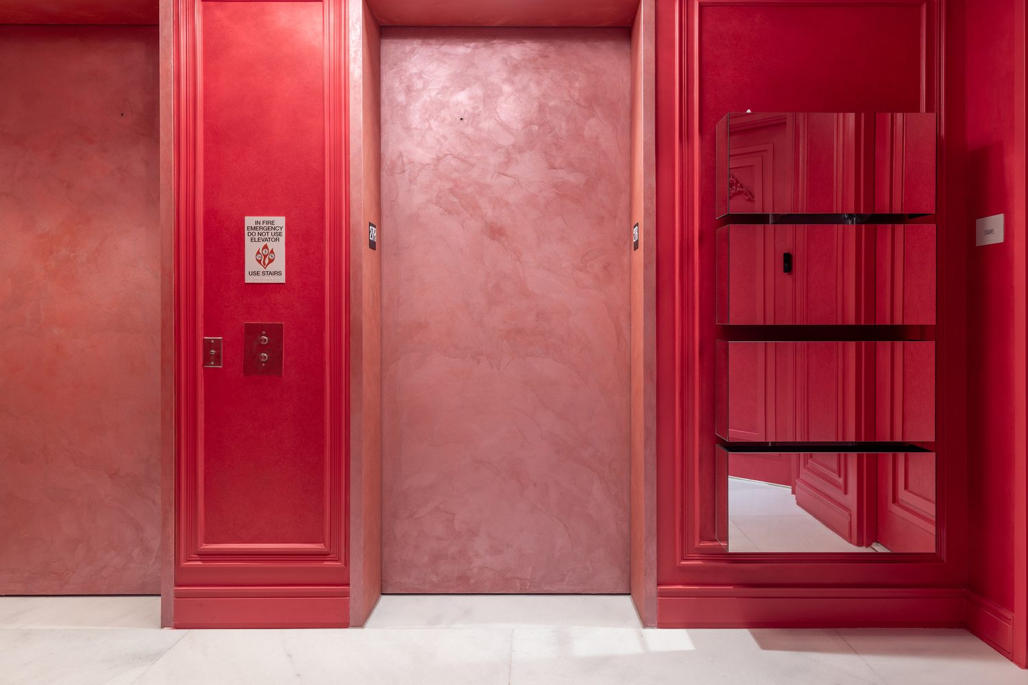 Elevator doors finished in limewash against polished plaster on the private landing